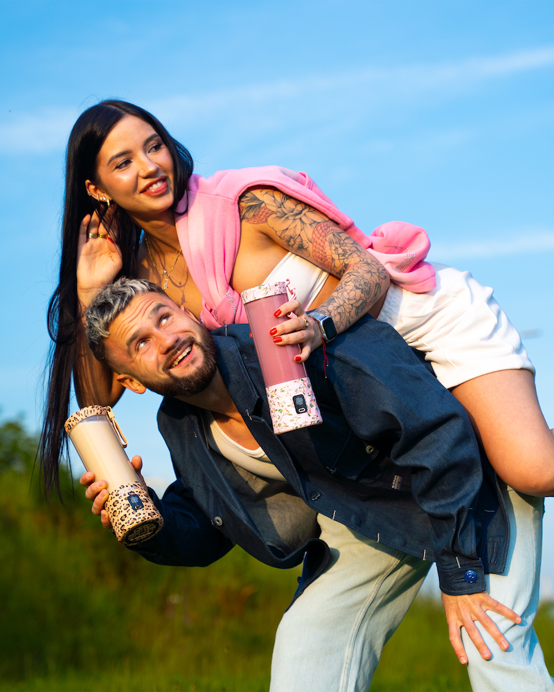 Muž nesoucí ženu na zádech s mixéry BlendyGo - formát na výšku